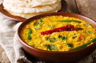 Spicy Indian thick soup Dal Tadka is a popular North Indian recipe close up in a bowl on the table. Horizonta clipart