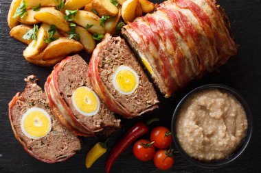 Yumurta ile Hackbraten rulo köfte patates dilimleri ve sos yakın masaya kayrak bir plaka üzerinde çekim ile devam eder. abov üzerinden yatay üstten görünüm