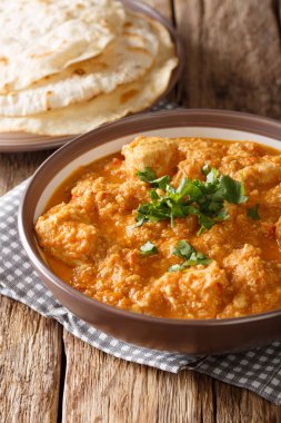  Domates, zencefil, sarımsak, soğan, yeşil chilies, taze kişniş (kişniş), baharat ve yağ yakın masada bir plaka üzerinde çekim bol Hint tavuk changezi pişirilir. Vertica