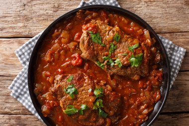 Lezzetli İsviçre biftek kızarmış ve baharatlı domates soslu sebze yakın çekim tablo ile ihtiva eder. Abov üzerinden yatay üstten görünüm