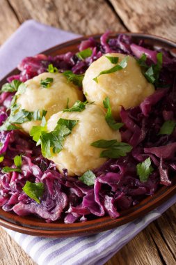 Alman gıda knodel patates köfte ve masaya bir tabak haşlanmış kırmızı lahana yakın çekim. Vertica