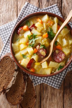 Masanın üzerine bir kase yakın çekim sosis ile lezzetli Alman patates sebze çorbası. Abov gelen dikey üstten görünüm