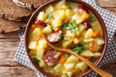 Yavaş Tencere Alman patates çorbası (kartoffelsuppe) bir tabak masaya yakın çekim. Abov üzerinden yatay üstten görünüm