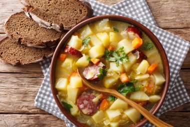 Masanın üzerine bir kase yakın çekim sosis ile lezzetli Alman patates sebze çorbası. abov üzerinden yatay üstten görünüm