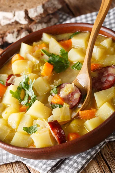 Traditional German kartoffelsuppe potato soup recipe with sausages close-up on the table. vertica