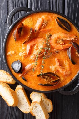 Katalan otantik baharatlı Suquet de Peix çorbası ile patates, karides, midye, otlar ve picad yakın çekim masada bir tavada balık. Abov gelen dikey üstten görünüm