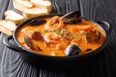 Deniz ürünleri baharatlı çorba, patates, karides, midye, otlar ve picad tatlı bir tavada balık ekmek ile servis. Horizonta