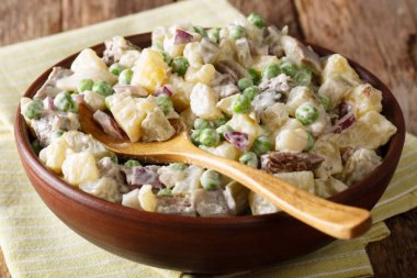 Letonya Baltık salata rasols sebze, ringa balığı ve sığır eti, masada bir kasede mayonez yakın çekim ile giyinmiş. Horizonta
