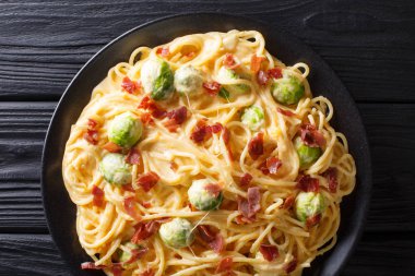 Peynirli spagetti, pastırma ve Brüksel lahanası peynir portre plaka üzerinde erime içinde kaplı. abov üzerinden yatay üstten görünüm