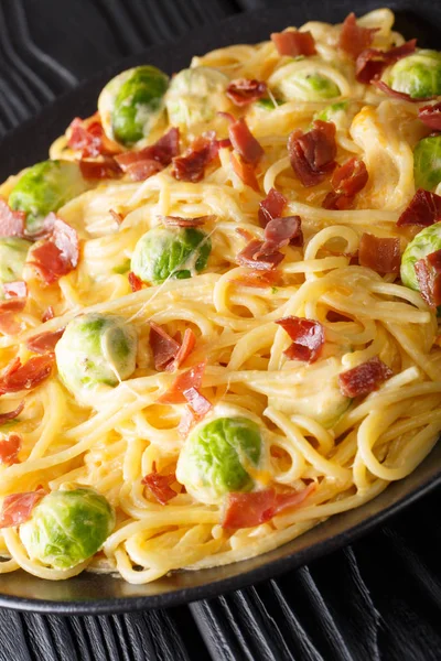 芽キャベツとテーブルの上の皿にチーズ ソースのクローズ アップとハムとイタリアのスパゲティ Vertica — ストック写真