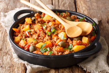 Sığır Picadillo ile patates, havuç, Kuru üzüm, zeytin ve baharat yakın çekim masada bir tavada pişirilir. Horizonta