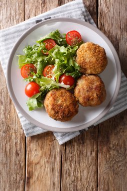 Lezzetli Danimarka domuz eti köftesi ile masaya bir tabak taze sebze salatası yakın çekim breading içinde kıyılmış. Abov gelen dikey üstten görünüm