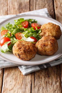 Danimarka domuz patty karbonader veya krebinetter ile bir tabak tablo taze salata yakın çekim. dikey