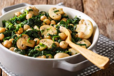 Nohut masanın üzerine bir kase ıspanak ve mantar yakın çekim ile sağlıklı vejetaryen yemek. Horizonta