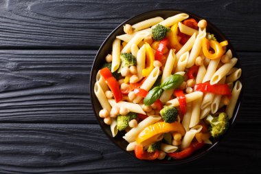 Penne makarna ile nohut, brokoli, biber ve baharat yakın çekim masaya bir tabak içinde. abov üzerinden yatay üstten görünüm