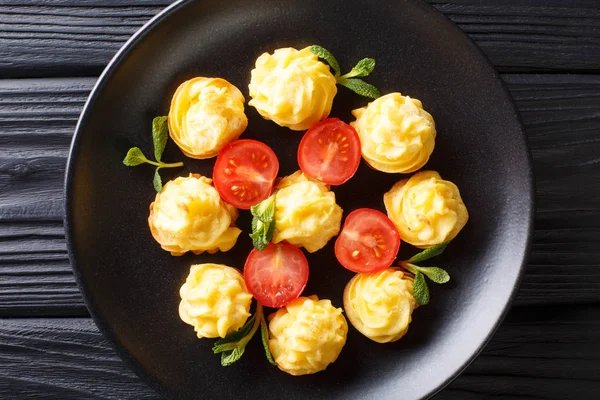 Batatas Duquesa servido com hortelã e tomate closeup em uma placa — Fotografia de Stock