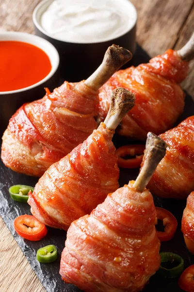 Sucettes de poulet enveloppées au bacon avec sauces gros plan. vertical — Photo