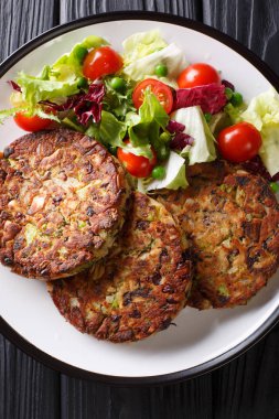 Vejetaryen mantar patty masada bir tabakta sebze salatası yakın çekim ile devam eder. Abov gelen dikey üstten görünüm