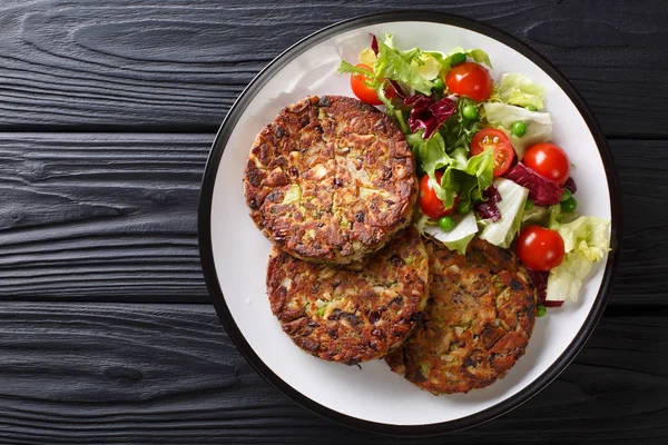Lezzetli mantar sebze köftesi masaya bir tabak yakın çekim üzerinde taze salata ile servis. abov üzerinden yatay üstten görünüm