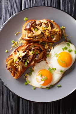 Shiitake mantar ve kaşar peyniri ile lezzetli kızarmış ekmek kızarmış yumurta yakın masada bir plaka üzerinde çekim ile devam eder. Abov gelen dikey üstten görünüm