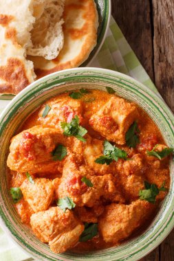 Bir baharatlı domates sosu closeup Karhai tavuk naan ekmek bir tablo ile devam eder. Abov gelen dikey üstten görünüm