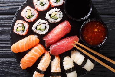 uramak ve iki soslar yakın çekim kayrak bir tabakta servis nigiri Japon rulo set. abov üzerinden yatay üstten görünüm