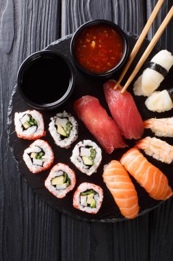 uramak ve iki soslar yakın çekim kayrak bir tabakta servis nigiri Japon rulo set. Abov gelen dikey üstten görünüm