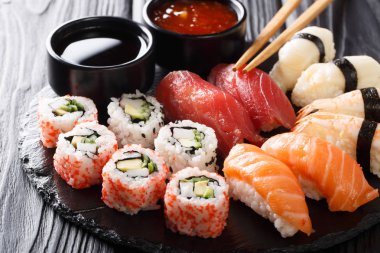 Taze maki, uramaki ve nigiri suşi, siyah saç yakın çekim hizmet kümesi. Horizonta