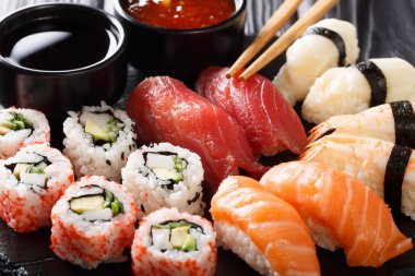 uramak ve iki soslar yakın çekim kayrak bir tabakta servis nigiri Japon rulo set. Horizonta