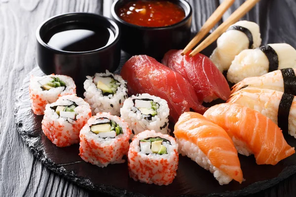 Taze maki, uramaki ve nigiri suşi, siyah saç yakın çekim hizmet kümesi. Horizonta
