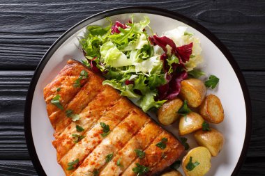 Patates kızartması ve taze salata yakın ahşap bir masa üzerinde bir plaka üzerinde çekim ile ızgara kılıç balığı fileto. abov üzerinden yatay üstten görünüm