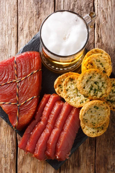 Füme balığı ve tost ile masaya sarımsak ve yeşillik closeup ile köpüklü bira hizmet. Abov gelen dikey üstten görünüm