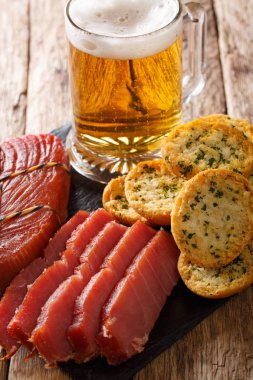 Köpük, füme ton balığı ve tost ile masaya sarımsak ve yeşillik closeup ile hafif bira. Vertica