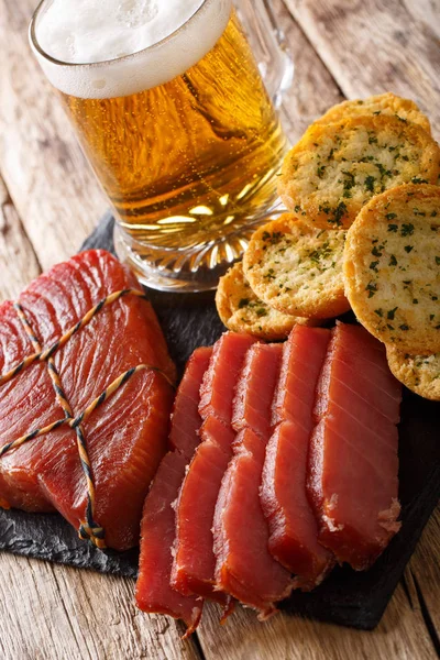 Füme balığı ve tost ile masaya sarımsak ve yeşillik closeup ile köpüklü bira hizmet. Vertica
