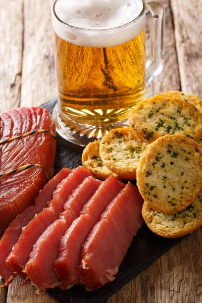 Köpük, füme ton balığı ve tost ile masaya sarımsak ve yeşillik closeup ile hafif bira. Vertica