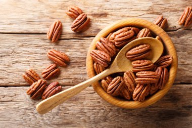 Pecans ahşap bir masa üzerinde bir kasede yarım. yukarıdan, rustik styl yatay üstten görünüm
