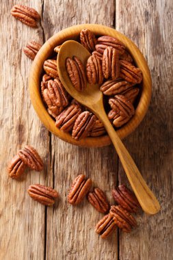 Pecans ahşap bir masa üzerinde bir kasede yarım. Yukarıdan, rustik styl dikey üstten görünüm
