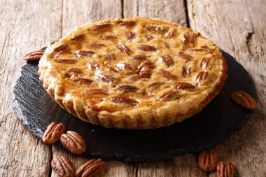 Kayrak bir tahta masanın üzerine tarçın ve karamel yakın çekim ile lezzetli cevizli kek. Horizonta