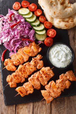 Geleneksel Taouk tavuk kebap Pide taze salata, yoğurt sos ile yakın çekim masada ekmek. Abov gelen dikey üstten görünüm