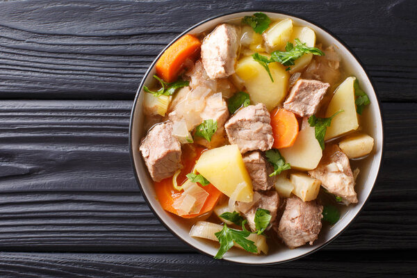 German stew Pihelsteiner with vegetables and three kinds of meat close-up in a bowl on the table. horizontal top view from abov