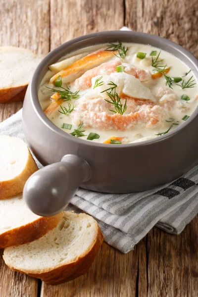 Delicious creamy fish soup with cod and salmon close-up in a bowl served with fresh bread on the table. vertica — Stock Image Delicious Creamy Fish Soup Cod Salmon Close Bowl Served Fresh Stock Photo