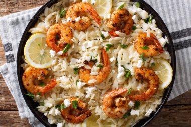 İtalyan makarna orzo ızgara karides ile beyaz peynir ve limon closeup masada bir tabakta. abov üzerinden yatay üstten görünüm