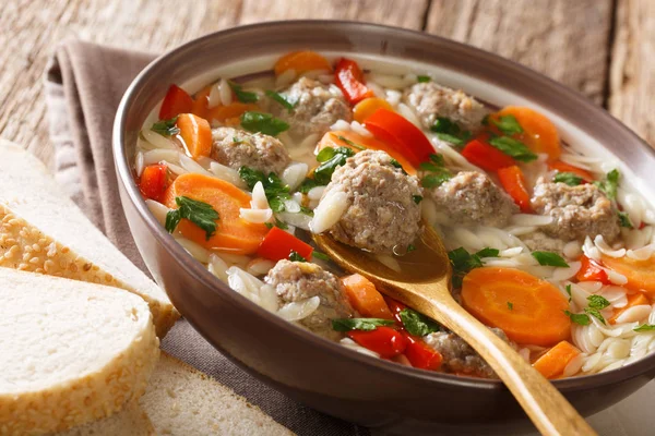 イタリア スープ パスタのオルゾー ミートボールと野菜のクローズ アップ プレートで焼きたてのパンを添えてください — ストック写真