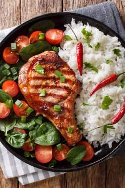 Izgara domuz eti pilav ve masaya bir tabak taze sebze salatası yakın çekim ile ev yapımı akşam yemeği. Abov gelen dikey üstten görünüm