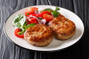Baharatlı kızarmış köfte crepinette ve masaya bir tabak taze sebze salatası yakın çekim. Horizonta