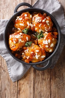 Kızarmış tavuk uyluk kuru kayısı ve badem closeup masada bir tavada ile sırlı. Abov gelen dikey üstten görünüm