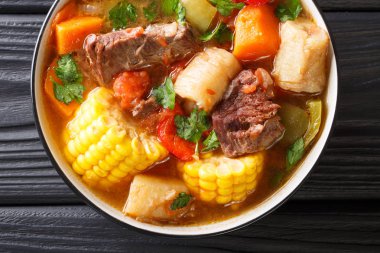 Masanın üzerinde bir tabakta sebze yakın çekim ile Latin Amerika Sancocho kalın et çorbası. Yukarıdan, rustik styl yatay üstten görünüm