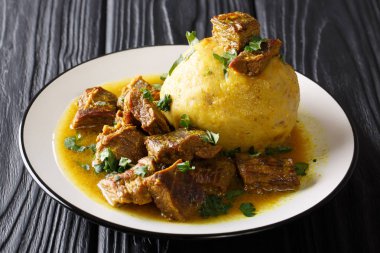 Plantain, sarımsak ve chicharron ile baharatlı mofongo masada bir tabakta et ve et suyu yakın çekim ile devam eder. Horizonta