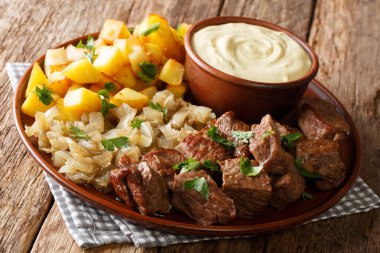 İsveçli sığır eti Rydberg kızarmış soğan ve hardal sosu yakın masada bir plaka üzerinde çekim ile gevrek patates ile. horizonta