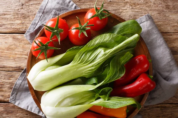 Cru sain bébé bok choy, tomates et poivrons gros plan sur un pla — Photo